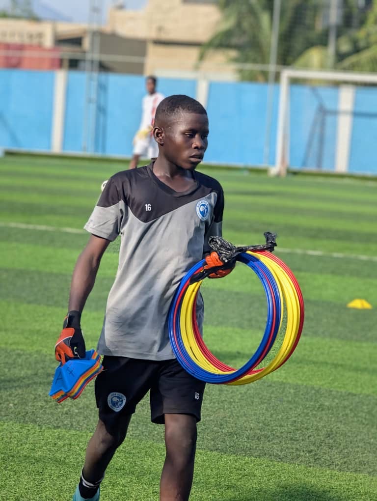 Young player helping carry the team’s training equipment